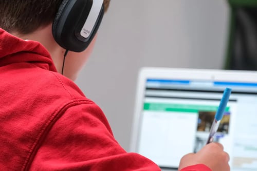 A young boy completes self-paced learning at his computer.